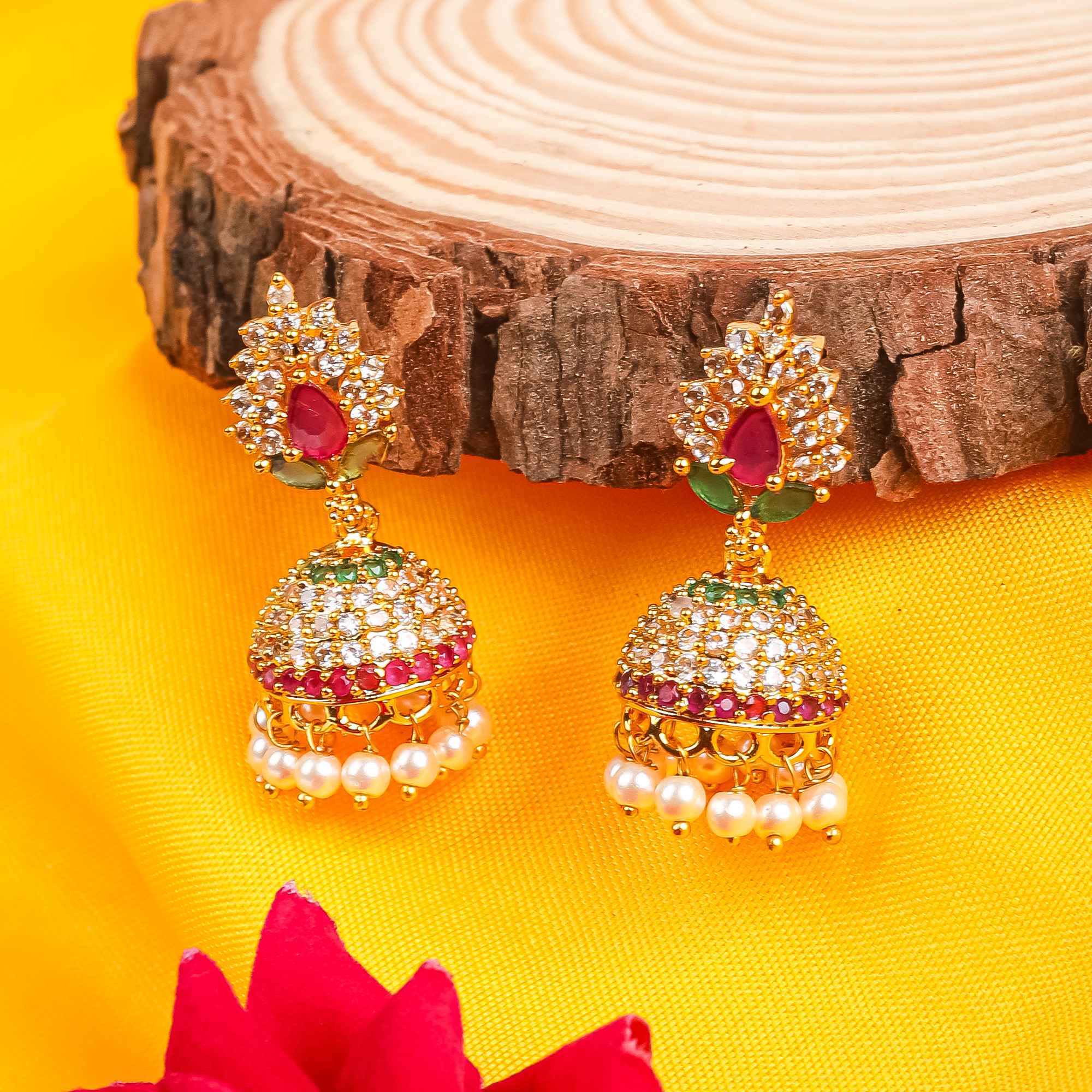Gold Plated Floral Jhumka Earrings with pink and green stones, pearls, and white crystals.