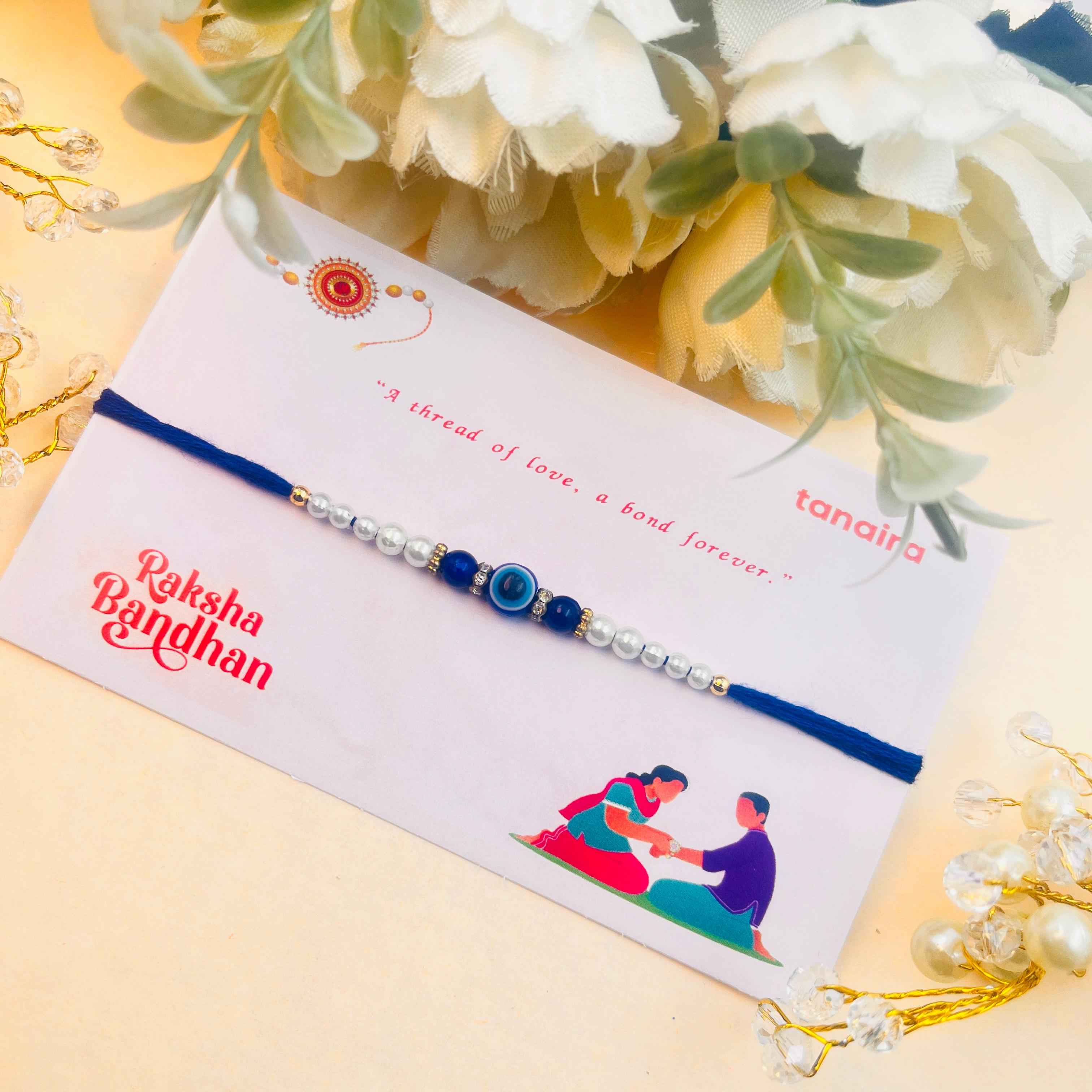 Rakhi with a card on a decorative background